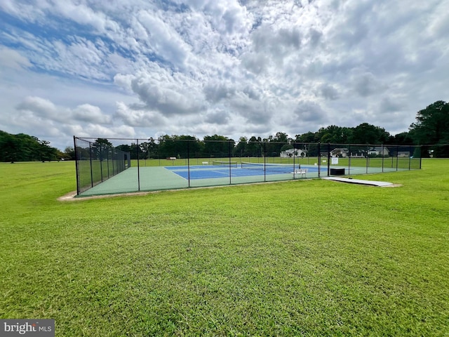 exterior space with tennis court and a lawn