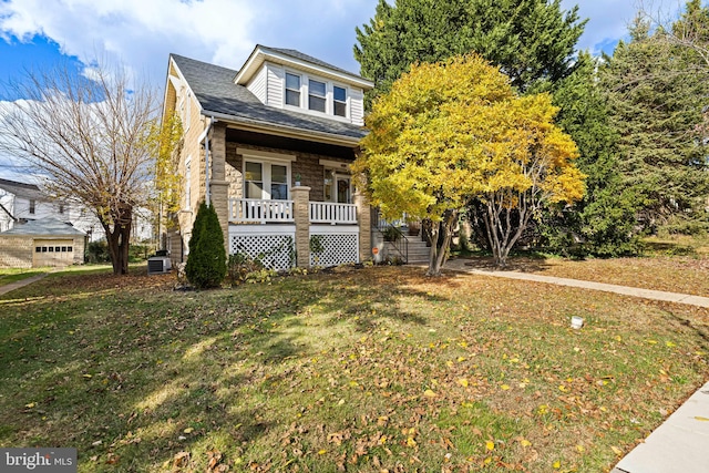 view of front facade featuring central AC unit, a porch, and a front yard