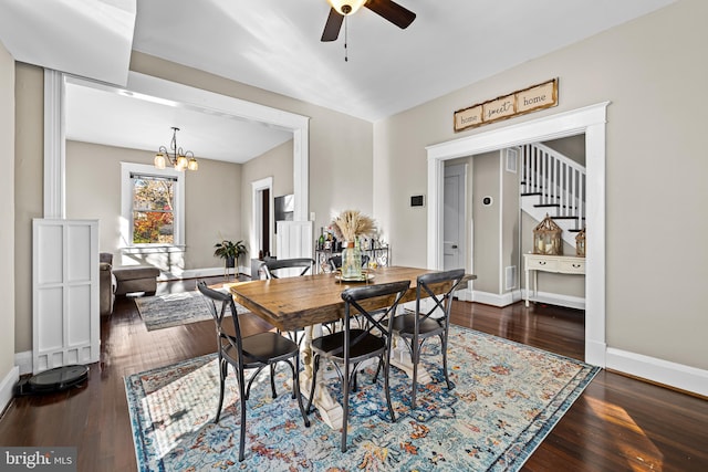 dining space featuring dark hardwood / wood-style floors and ceiling fan with notable chandelier