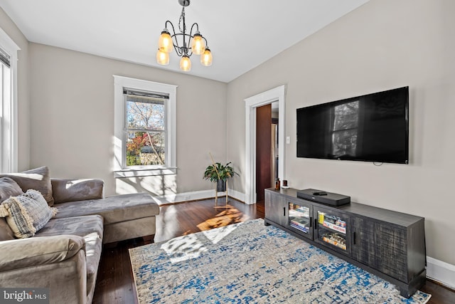 living room featuring dark wood-type flooring and a notable chandelier