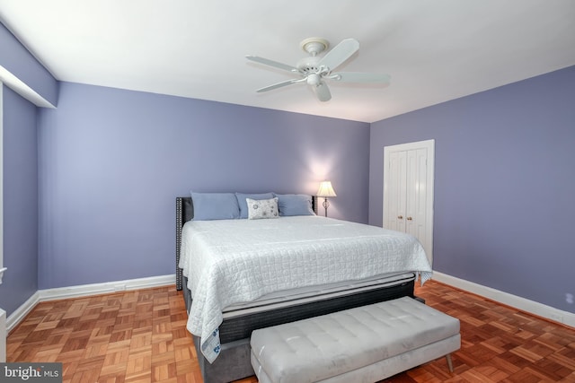bedroom with ceiling fan, parquet floors, and a closet