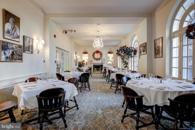 dining space featuring crown molding, french doors, and a chandelier