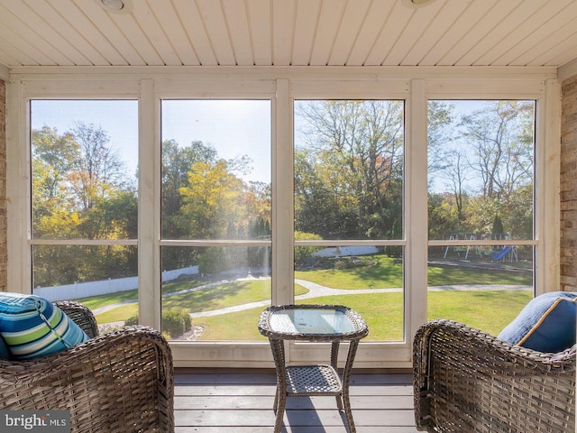 sunroom featuring a water view and a healthy amount of sunlight