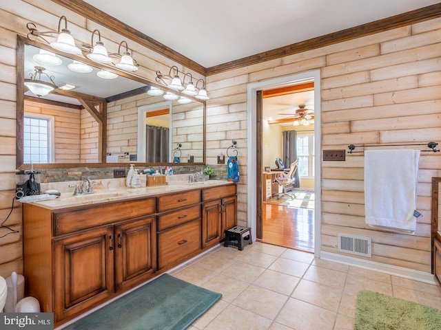 bathroom with rustic walls, ceiling fan, and a healthy amount of sunlight