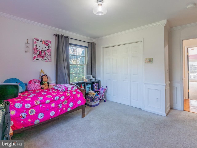 carpeted bedroom with crown molding and a closet