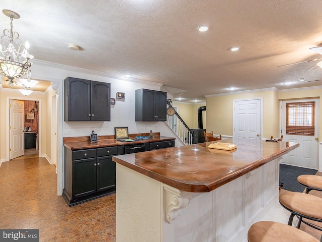 kitchen with pendant lighting, a center island, a textured ceiling, and wooden counters