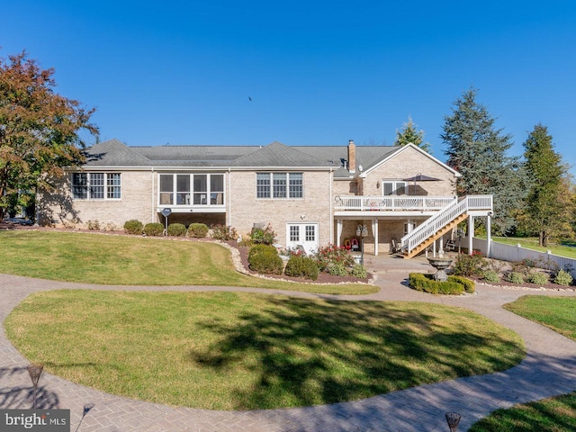 view of front of property featuring a front yard, a patio, and a wooden deck