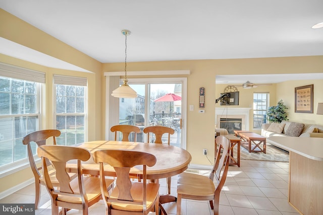 dining space with light tile patterned flooring, a wealth of natural light, and ceiling fan