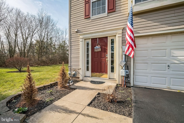 property entrance featuring a yard and a garage