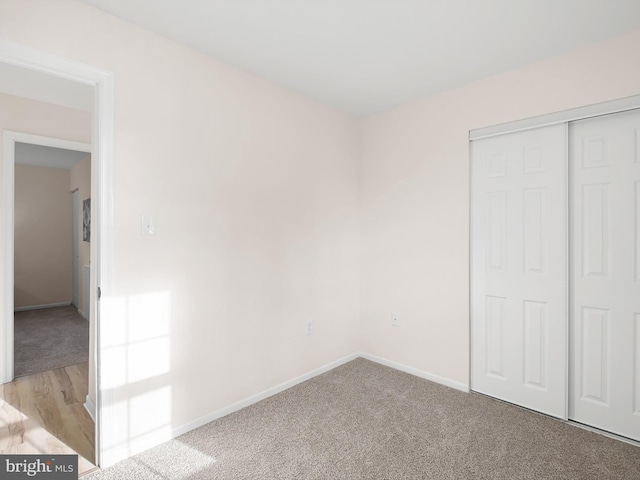 unfurnished bedroom featuring light colored carpet and a closet