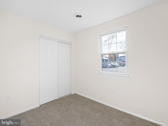 unfurnished bedroom featuring carpet floors and a closet