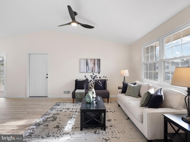 living room with ceiling fan, light wood-type flooring, and vaulted ceiling