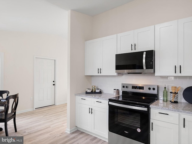 kitchen with decorative backsplash, light hardwood / wood-style flooring, white cabinets, and stainless steel appliances