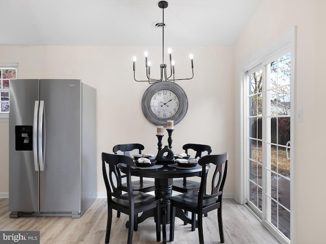 dining room with light hardwood / wood-style floors and an inviting chandelier