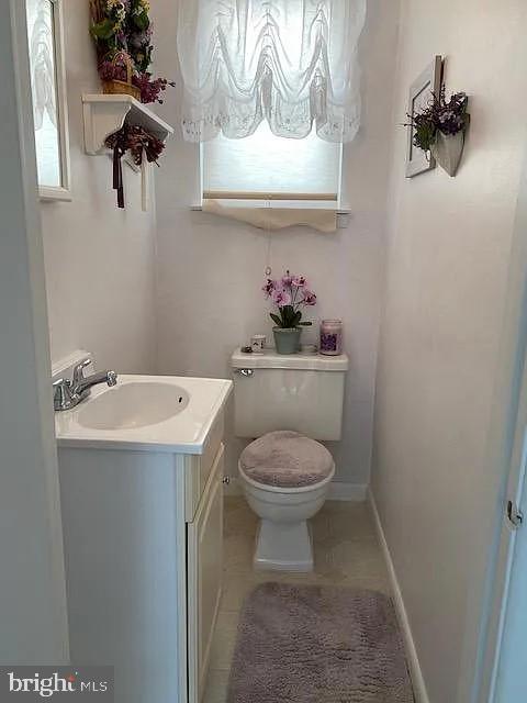 bathroom featuring tile patterned flooring, vanity, toilet, and plenty of natural light