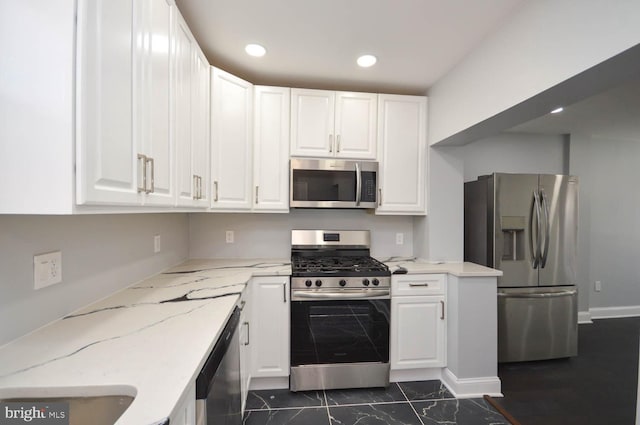 kitchen with light stone counters, white cabinetry, and appliances with stainless steel finishes