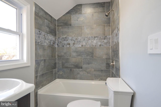 full bathroom with tiled shower / bath combo, toilet, lofted ceiling, and vanity