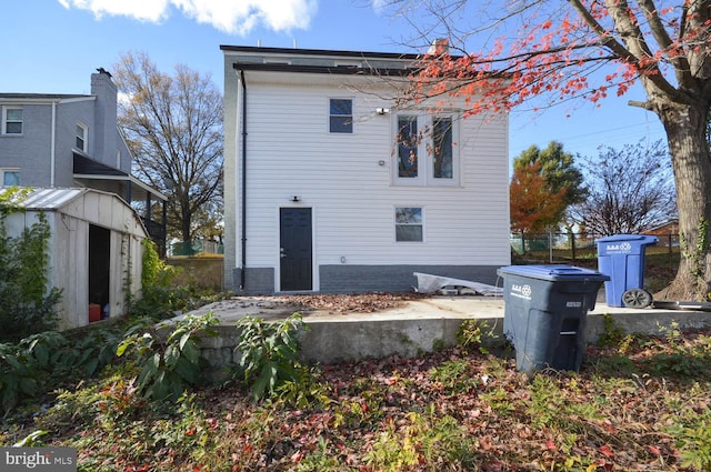 rear view of house with a storage shed