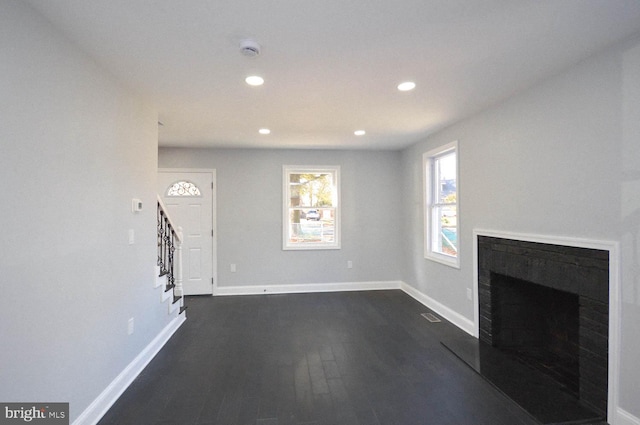 unfurnished living room with dark wood-type flooring