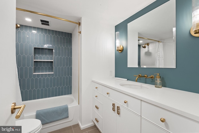 full bathroom featuring tile patterned floors, vanity, tiled shower / bath combo, and toilet