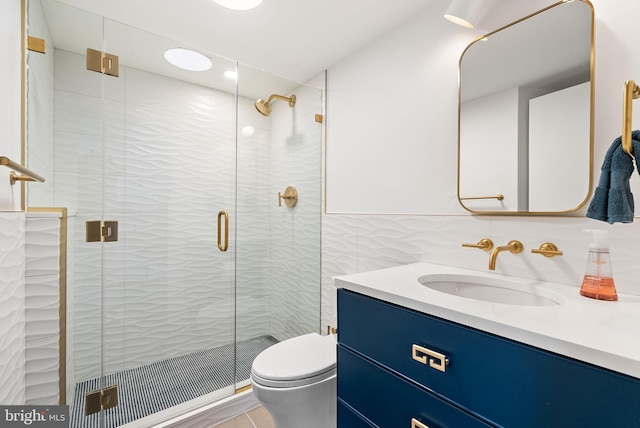 bathroom with walk in shower, vanity, toilet, and tile walls