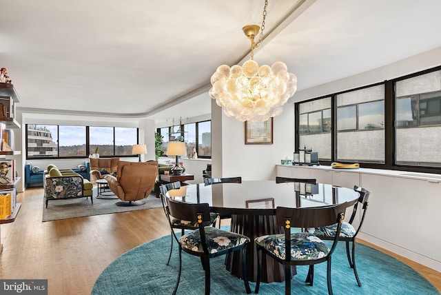 dining area featuring wood-type flooring and a notable chandelier