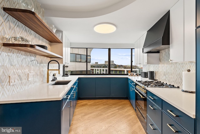 2510 Virginia Ave NW Unit 1104-N, Washington, DC 20037 - kitchen with custom exhaust hood, blue cabinetry, open shelves, high end range, and tasteful backsplash