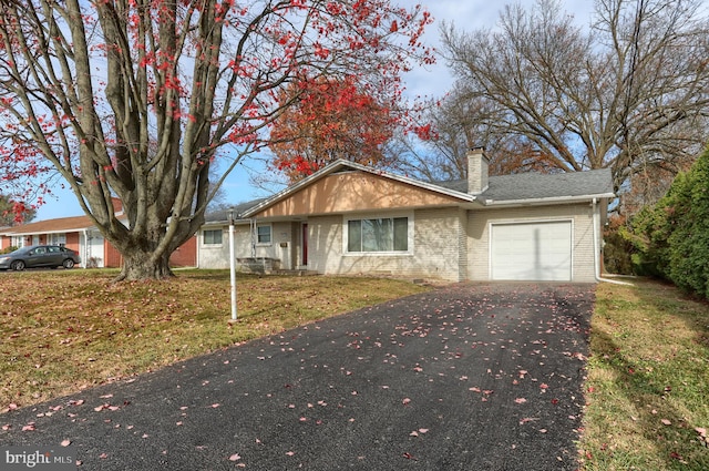 ranch-style house with a garage and a front lawn