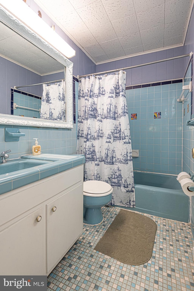 full bathroom with crown molding, toilet, shower / tub combo with curtain, vanity, and tile walls