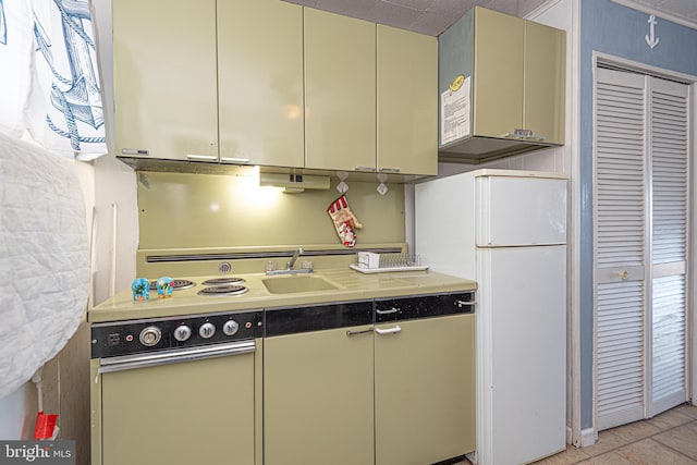 kitchen featuring sink, light tile patterned flooring, and white refrigerator