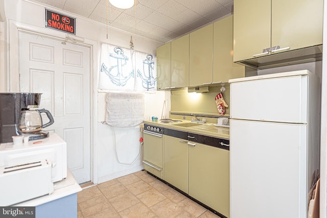 kitchen featuring white fridge and green cabinetry