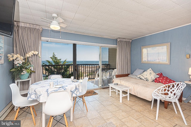 dining room featuring a water view, baseboard heating, ceiling fan, and ornamental molding