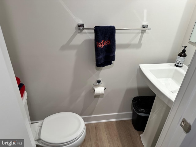 bathroom with hardwood / wood-style floors and toilet