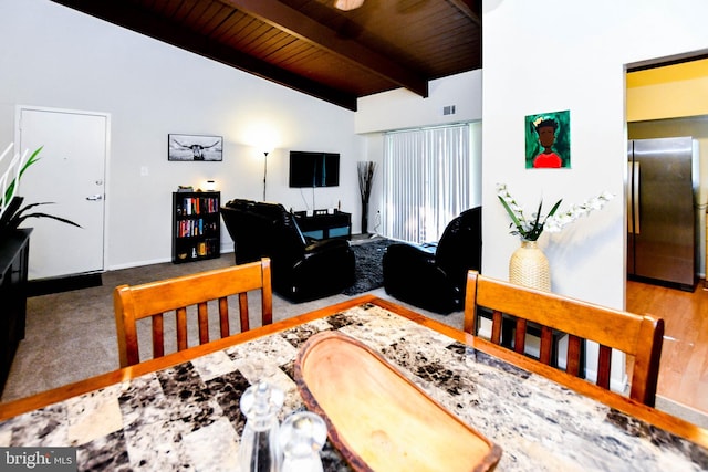 dining space featuring vaulted ceiling with beams, wood ceiling, and hardwood / wood-style flooring