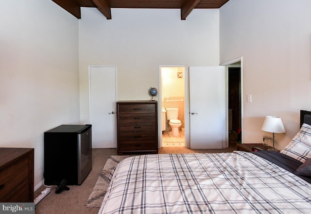 bedroom with beam ceiling, connected bathroom, stainless steel fridge, and light colored carpet