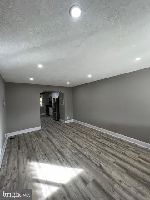 unfurnished living room with a textured ceiling and hardwood / wood-style flooring