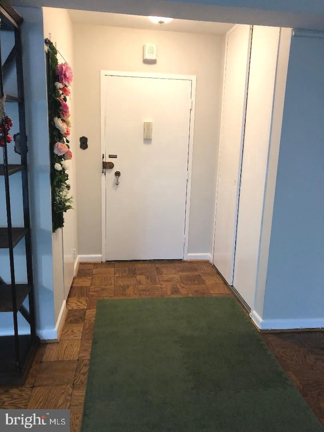 doorway to outside with dark parquet flooring