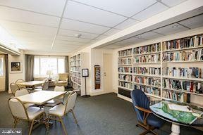 carpeted dining area with a drop ceiling