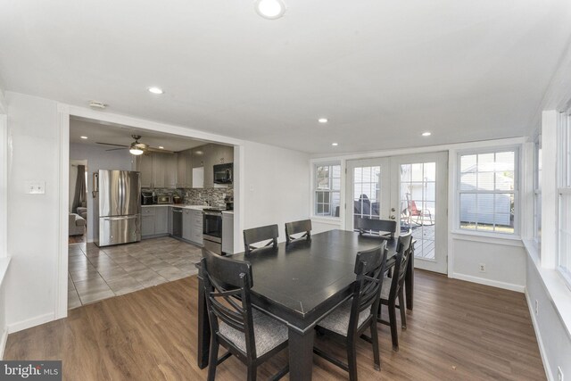 dining space with plenty of natural light, wood finished floors, recessed lighting, french doors, and baseboards