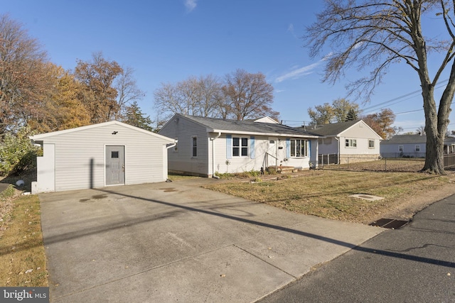 view of front of house featuring an outdoor structure, fence, and concrete driveway