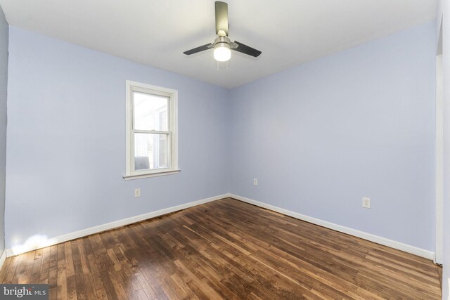unfurnished room with dark wood-style flooring, baseboards, and a ceiling fan