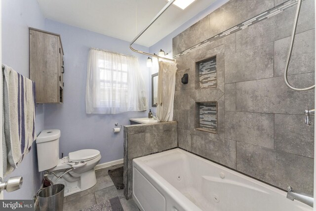 full bathroom with toilet, baseboards, and a combined bath / shower with jetted tub