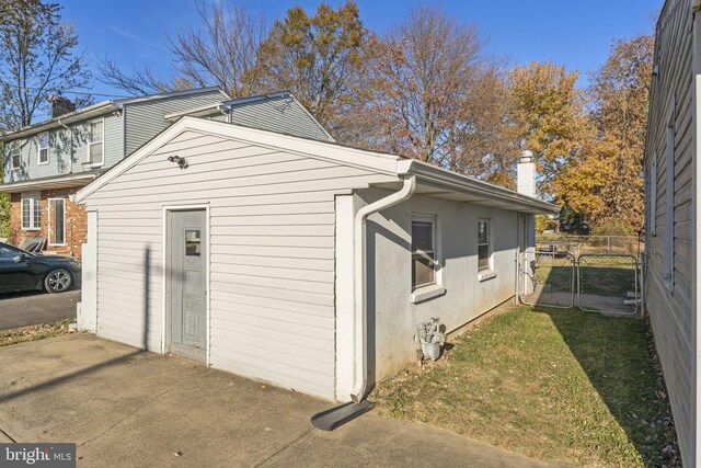 view of side of home featuring fence and a gate
