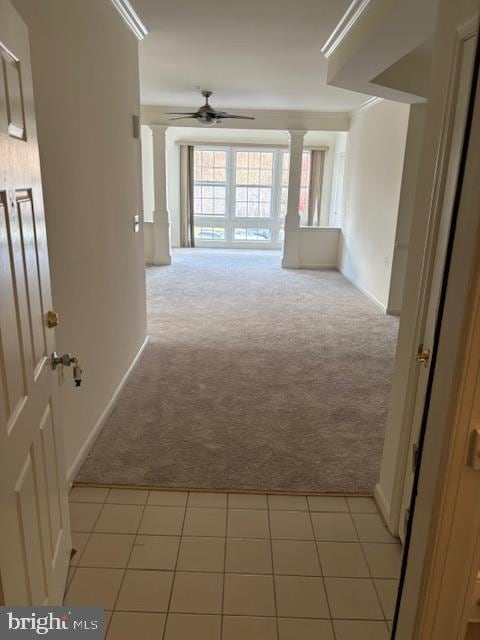 hallway featuring light colored carpet, decorative columns, and crown molding