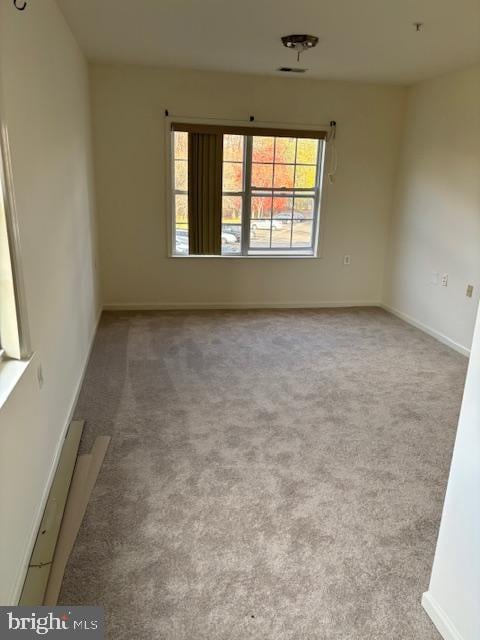 spare room featuring light colored carpet