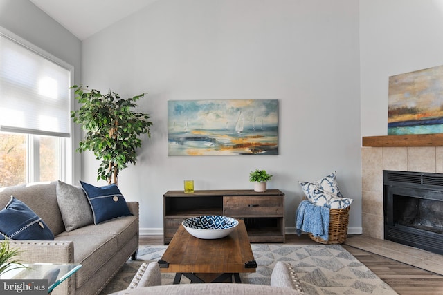 living room featuring wood-type flooring, a fireplace, and high vaulted ceiling