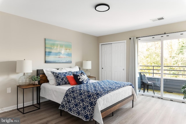 bedroom with access to outside, hardwood / wood-style flooring, and a closet