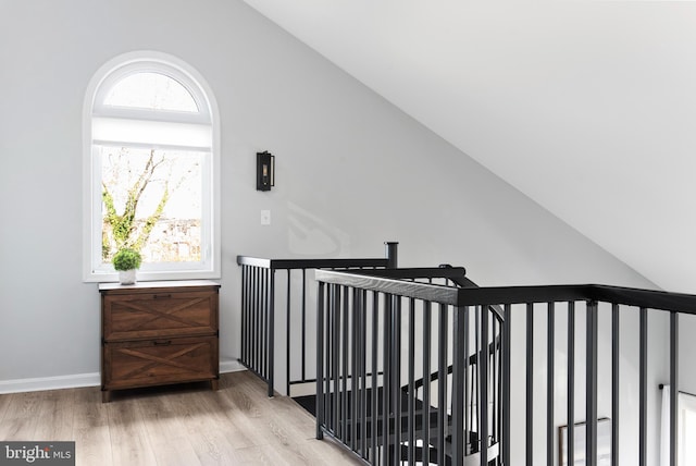 interior space featuring lofted ceiling and light hardwood / wood-style flooring