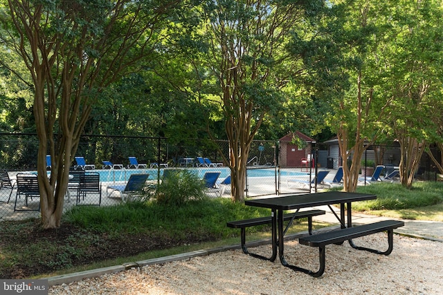 view of property's community with a pool and a shed