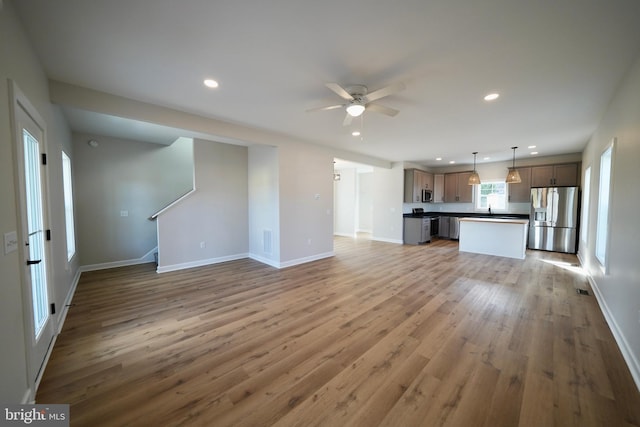 unfurnished living room with ceiling fan and hardwood / wood-style flooring